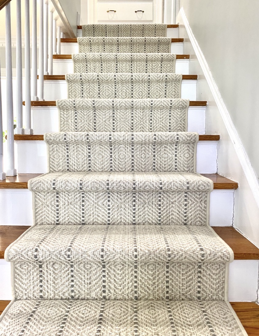 Neutral wool stair runner installed on straight wood staircase