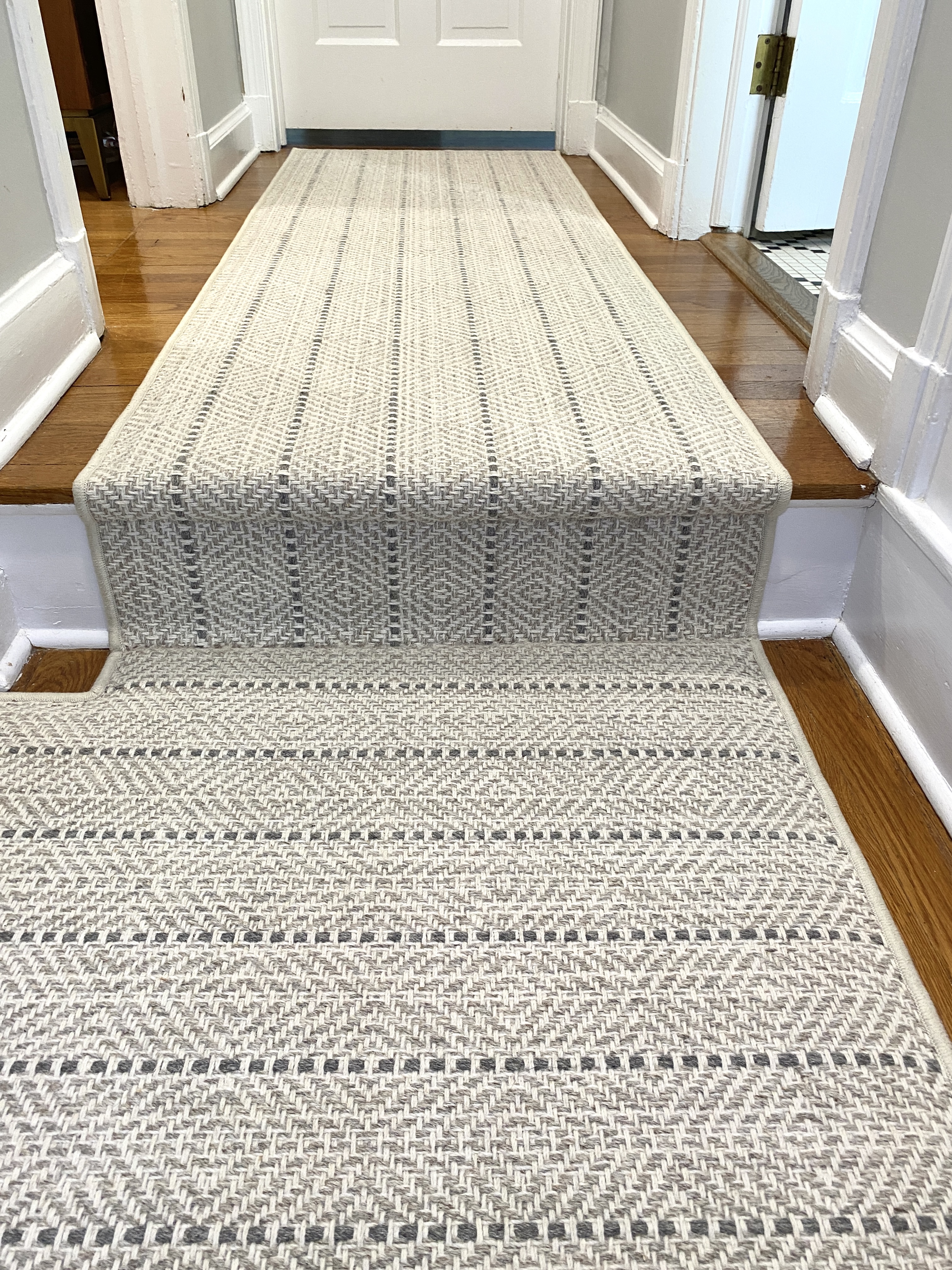 Custom wool stair runner continuing across a staircase landing