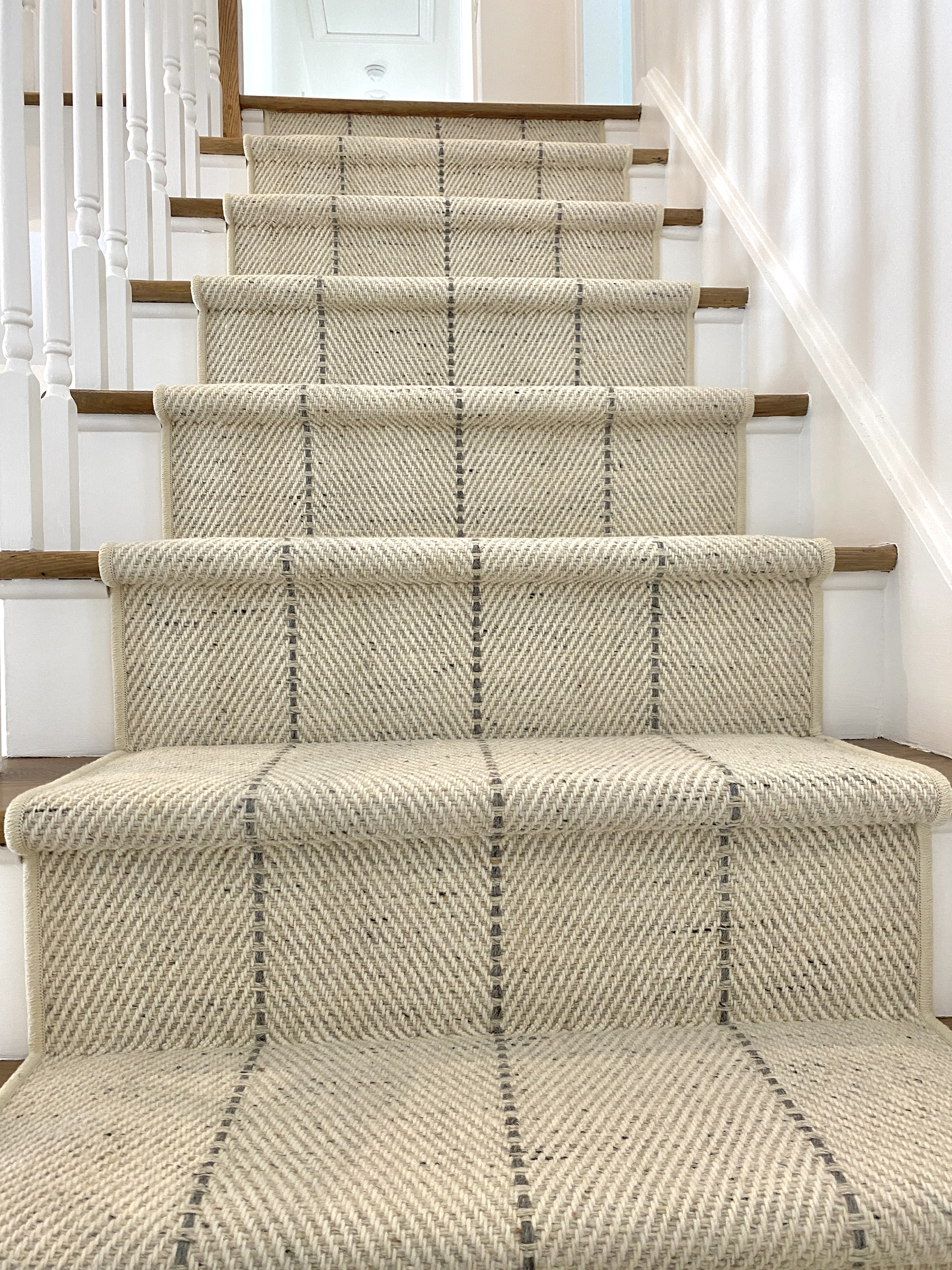 Custom patterned wool stair runner professionally installed on hardwood steps