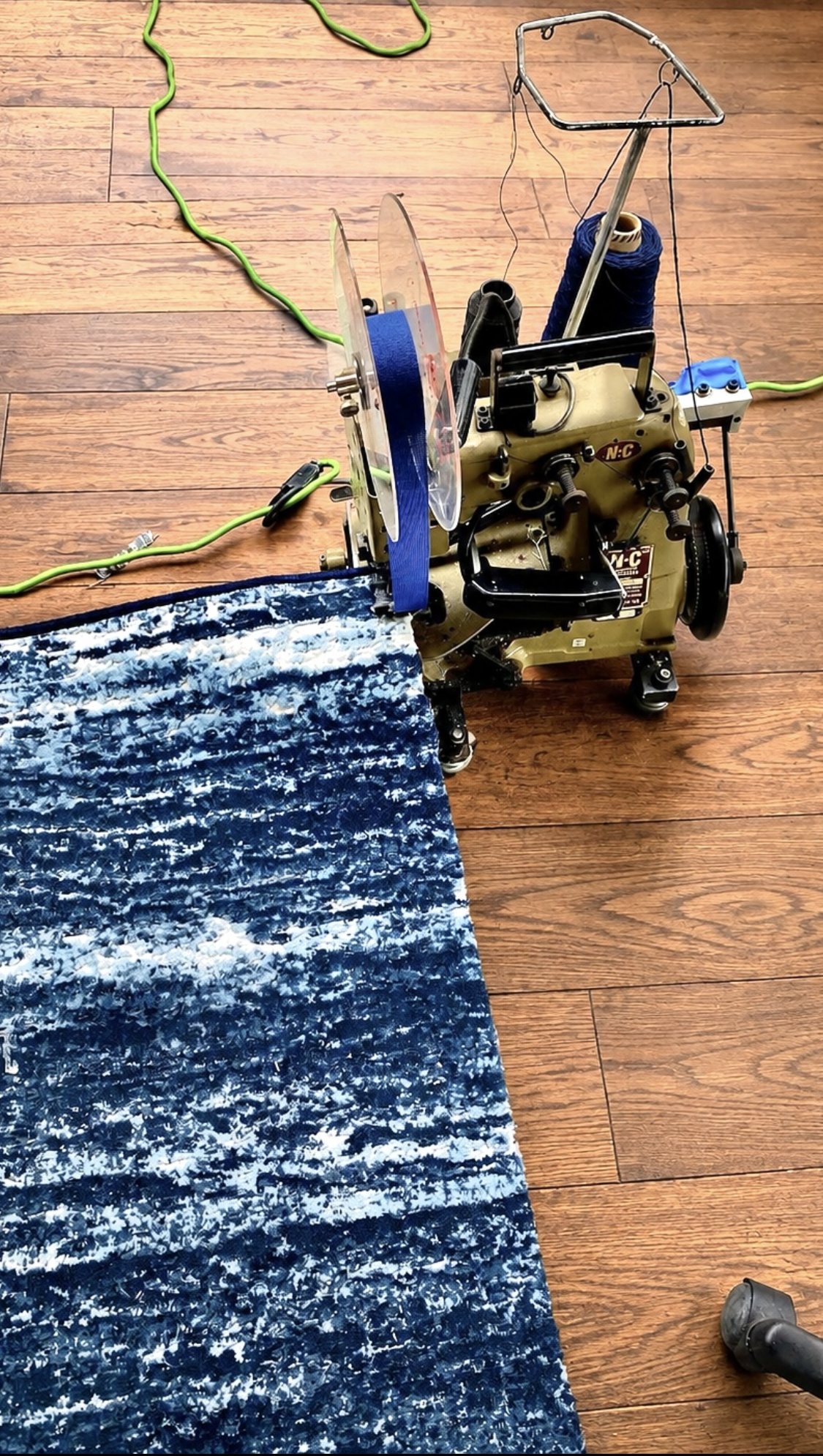 Carpet being professionally finished with a serging machine for a custom stair runner