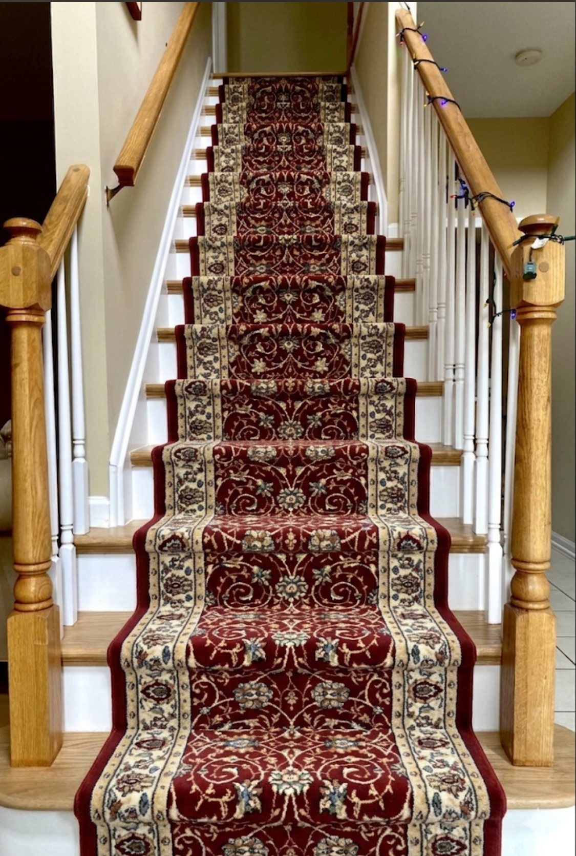 Traditional red Oriental-style stair runner installed on a wood staircase