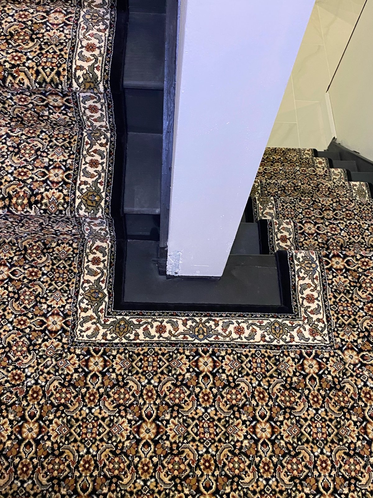 Traditional Oriental-style runner continuing across a staircase landing